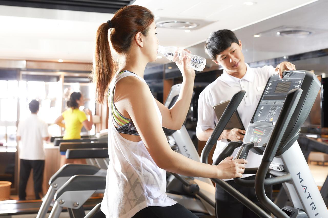 The Howard Prince Hotel Taichung Exterior photo A personal trainer assisting a woman on a treadmill